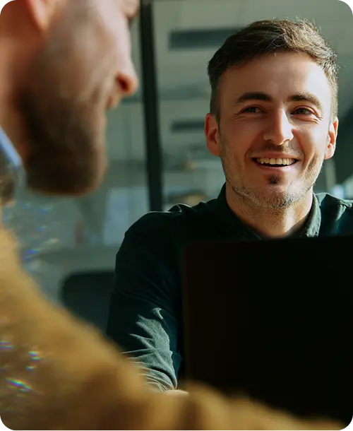 Two colleagues smiling during a business meeting