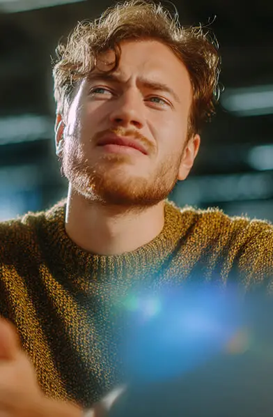 Man looking thoughtful in sunlight indoors