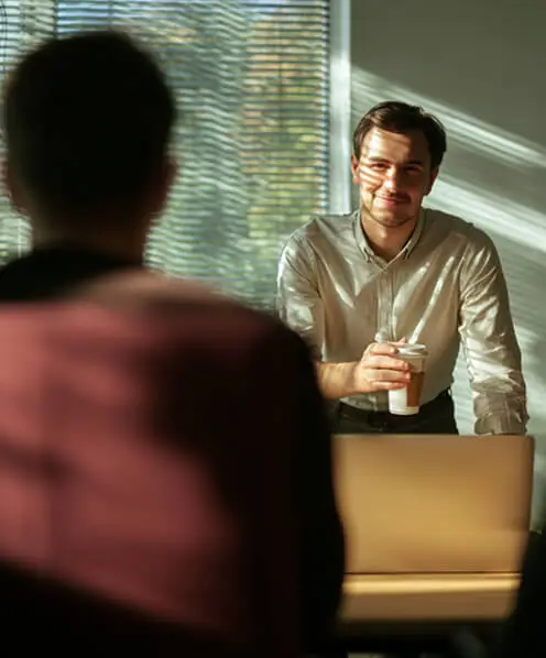 Man holding coffee cup during office meeting